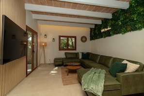 A modern living room with a sectional sofa, a coffee table, and a TV.