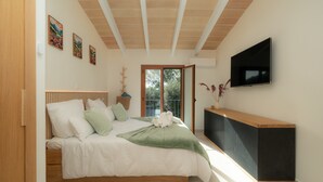 A bedroom with a bed, a TV, a window, and a door. - Villa 'Marloria' with Mountain Views, Wi-Fi, and Air Conditioning (Crestatx)