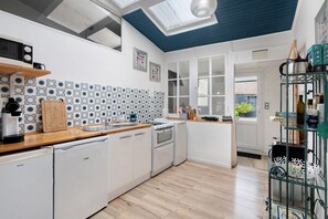 A compact kitchen with white cabinets, a wooden countertop, and a tiled backsplash. - Au Bois Dormant Holiday Home (Crécy en Ponthieu)
