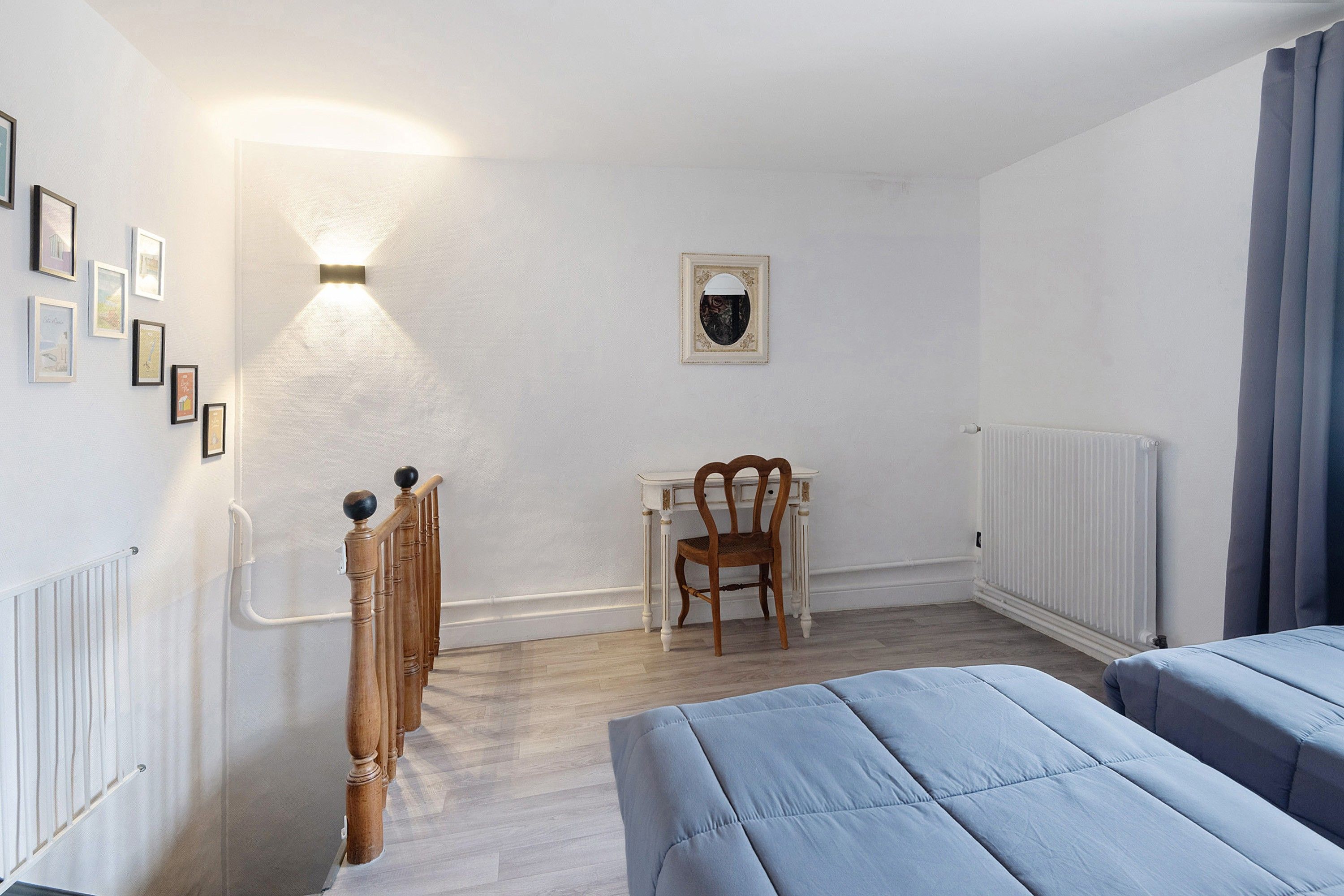 Una habitación con cama, escritorio, silla y radiador.