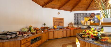 Une cuisine avec des meubles en bois, un plan de travail en granit et une variété d’aliments exposés.