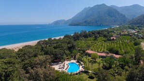 Un complexe hôtelier doté d’une piscine, d’une plage et offrant une vue sur les montagnes.