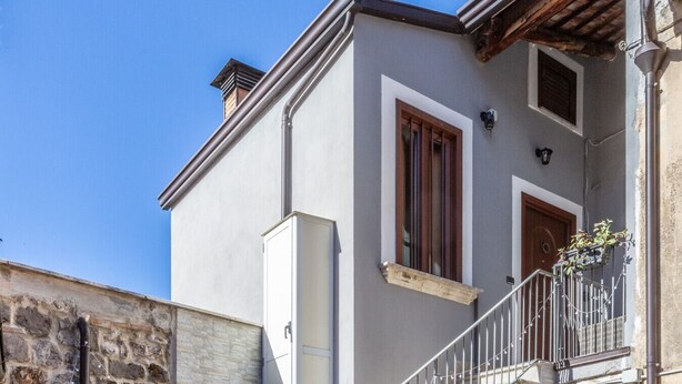 Ein Gebäude mit Balkon, Fenster und einem kleinen Anbau.