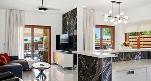 A modern kitchen with a marble countertop, a built-in TV, and a dining area with a view of the outdoors. - Villa HG08 Pyrinas - Three Bedroom Villa, Sleeps 6 (Kouklia)