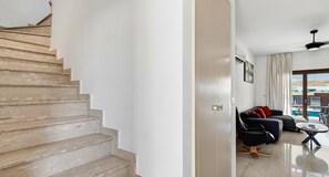 A staircase leading to a living area with a sofa and a coffee table.