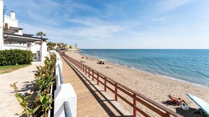 A beach with a wooden walkway and a red railing. - Beachfront holiday home in Malaga (Malaga)