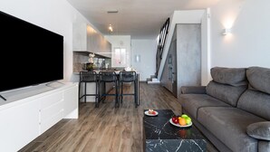 A modern living room with a large flat-screen TV, a grey sofa, and a marble coffee table. - Beachfront holiday home in Malaga (Malaga)