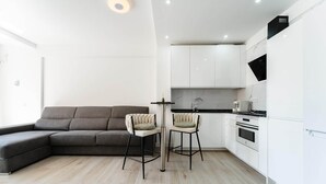 Eine moderne Küche mit weißen Schränken, einer schwarzen Arbeitsplatte und einem eingebauten Backofen.