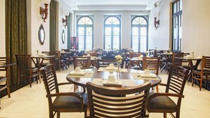 A large dining hall with multiple tables and chairs, large windows, and chandeliers. - Celebrate Love in Style—Bridal Suite with Breakfast Buffet in Curitiba’s Spot (State of Paraná)