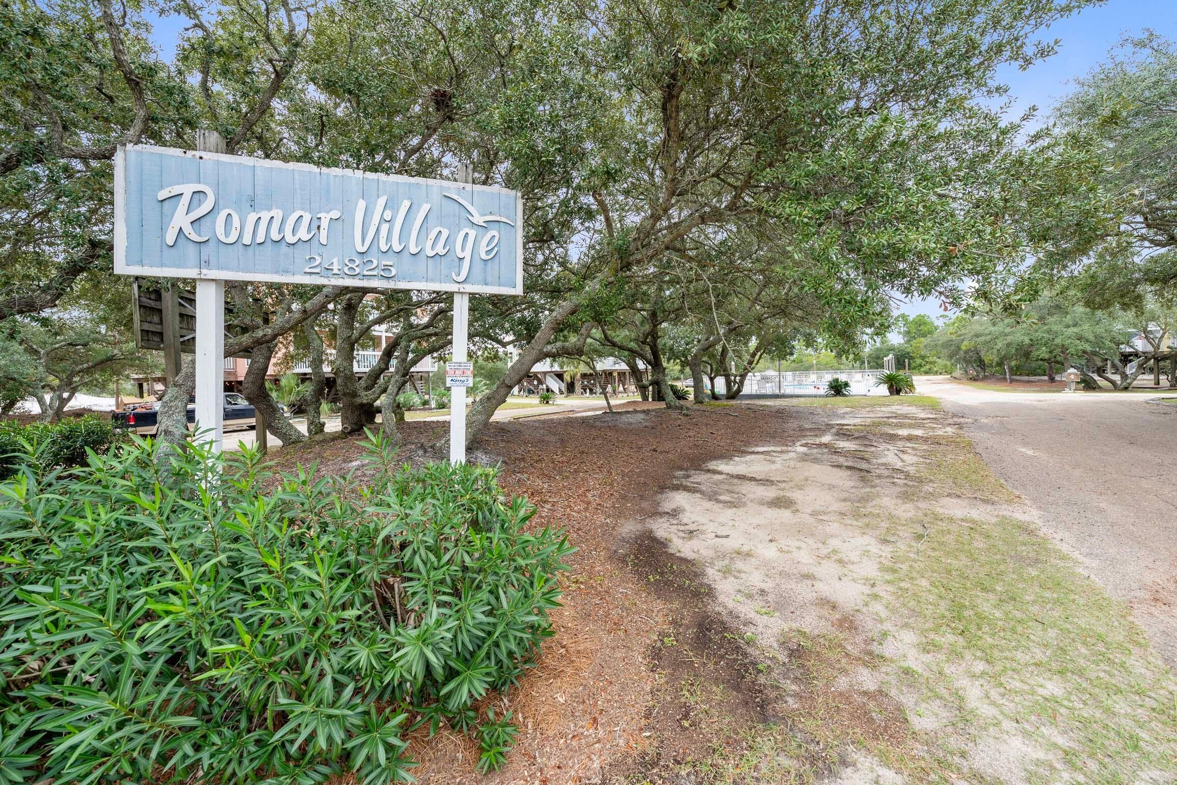 A sign for Romar Village with a phone number.