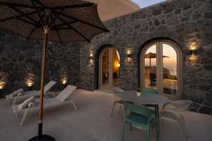 A stone building with arched windows, outdoor seating, and a table with chairs. - Villa Euthymia, 1 BDR, Wonderful Seaviews, Private Pool, Santorini (Santorini)