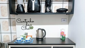 A kitchenette with a black countertop, a coffee maker, a kettle, and a coffee cup. - Complete House in Foz do Iguaçu/PR/Brazil - Sleeps 5 (Foz do Iguaçu)