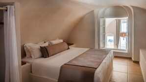 Ein Schlafzimmer mit Bett, Fenster und Blick ins Freie.