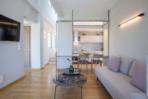 Una sala de estar moderna con un sofá, una mesa de centro y un televisor montado en la pared.
