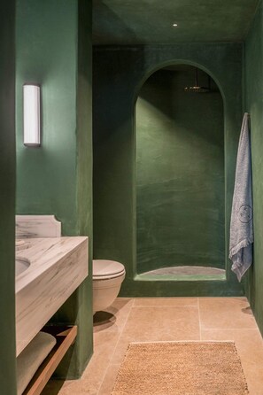 Une salle de bain avec un lavabo en marbre, des toilettes et une serviette accrochée au mur.