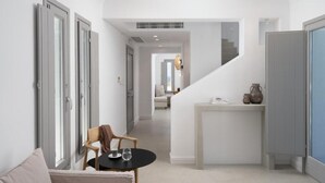 Un interior moderno con una escalera, un comedor con mesa y sillas, y vistas a una sala de estar.