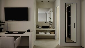 Una habitación moderna y minimalista con televisión de pantalla plana, escritorio, silla, espejo grande y vestidor.
