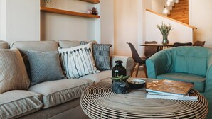 Un salon moderne avec un canapé, une table basse ronde et une bibliothèque.