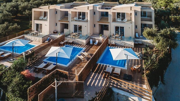 Un hôtel moderne à plusieurs étages, doté d’une piscine sur le toit, d’un espace extérieur aménagé et offrant une vue panoramique sur les collines environnantes.