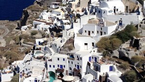 A coastal village with white-washed buildings, steeply pitched roofs, and a narrow street winding through the area. - Alluring Athens Suite | Artemis Suite | 1 Bedroom | Private Furnished Balcony. (Athens)