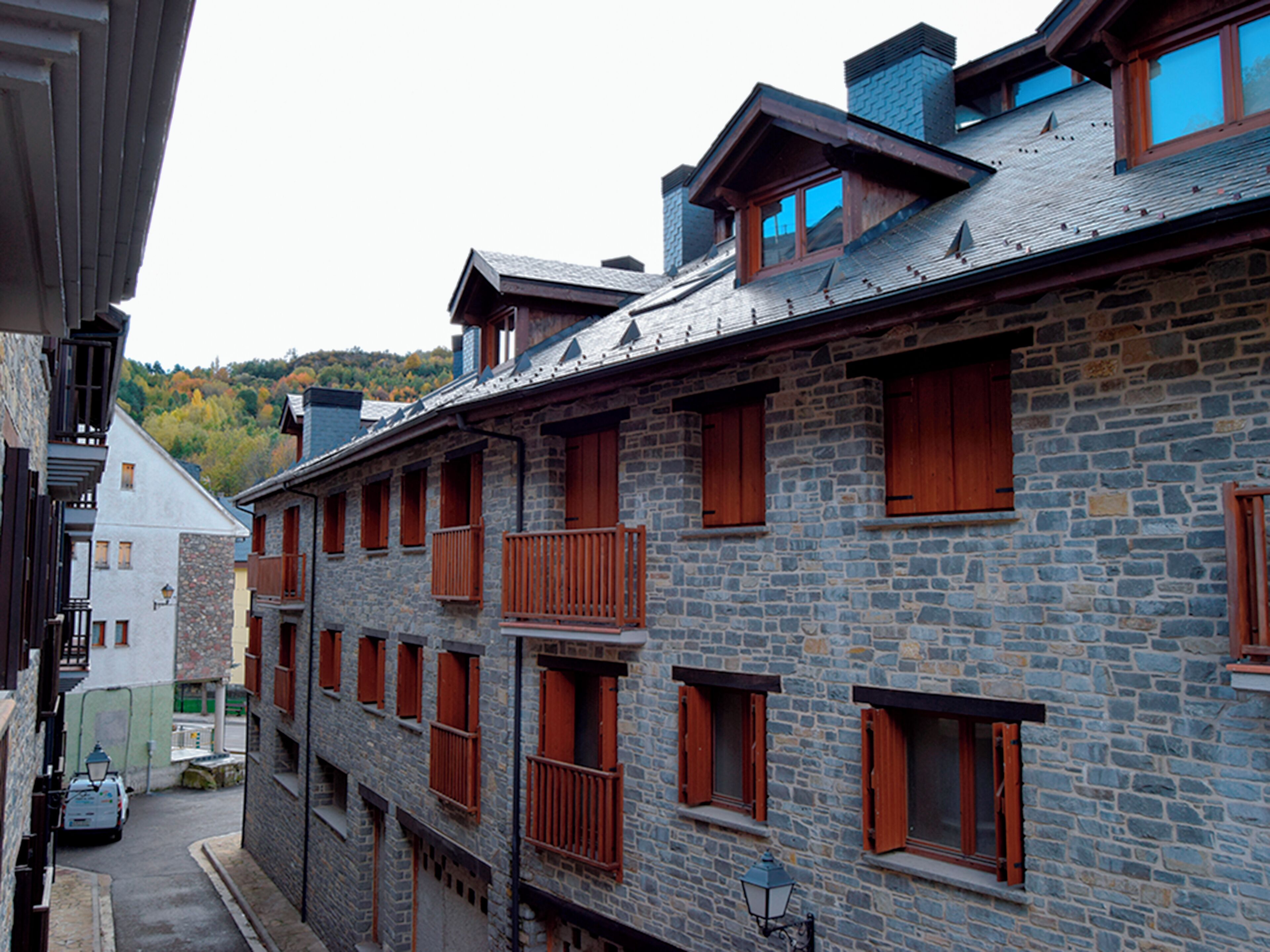 Un edificio de varios pisos de piedra con balcones y ventanas de madera.