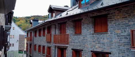 Un edificio de varios pisos de piedra con balcones y ventanas de madera.