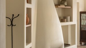 Un intérieur moderne avec un mur incurvé au design original, une cheminée et un porte-manteau.