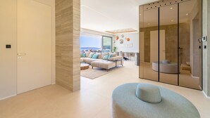 Een moderne woonkamer met een ruime hoekbank, een ronde salontafel en een glazen scheiding met uitzicht.