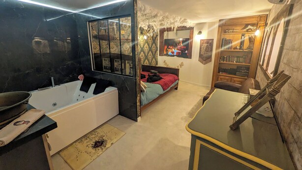A room with a bathtub, a bed, a desk, and a bookshelf. - The Sorcerer's Den (Caumont-sur-Durance)