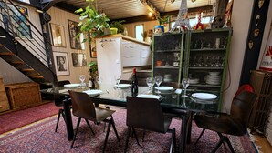 A dining area with a glass table, chairs, and a patterned rug.