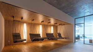 A modern room with a wooden slatted wall, a large window, and a wooden floor.