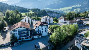 A town with buildings, a road, and mountains in the background.