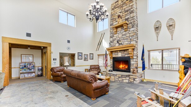 A spacious living area with a stone fireplace, leather sofas, and a fireplace screen. - Peak Location Near Slopes & Olympic Park (Park City)