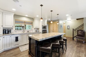 A spacious kitchen with a large island, built-in appliances, and a dining area with bar stools. - Family Friendly Townhouse with Private Hot Tub (Park City)