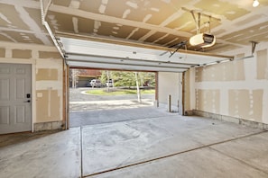 A garage with an open door, concrete floor, and a metal roof structure. - Bears Lair | Private Hot Tub & Mountain Views (Park City)