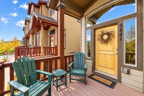 A wooden deck with Adirondack chairs, a wooden door with a wreath, and a clear sky. - Bears Lair | Private Hot Tub & Mountain Views (Park City)