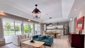 Ein modernes Wohnzimmer mit einer Couch, einem Couchtisch und einem Essbereich mit Stühlen und einem Tisch.