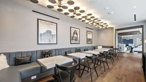 A modern restaurant with a long counter, black chairs, and a grey cushioned bench. - New! Lux Studio Lake Views | Trails & Adventure | Free shuttle to Gondola (Park City)