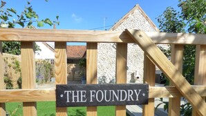 A wooden gate with a sign that reads "THE FOUNDRY." - The Foundry - sleeps 6 guests  in 3 bedrooms (Burnham Market)