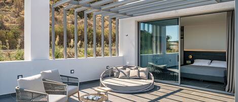 Eine moderne Außenpatio mit Korbmöbeln, einer runden Sitzecke und einem Bett mit Blick.