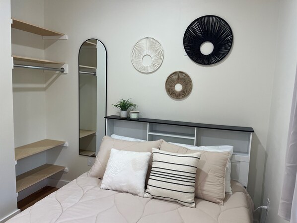 A bedroom with a bed, a bedside table, a mirror, and wall decorations. - Winney Hill Studios #1 of 8 Studios - Handicap - Full Renovation, 1 mile to ASV (Oneonta)