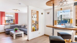 Una sala de estar moderna con un sofá, una mesa de centro y un comedor con barra.