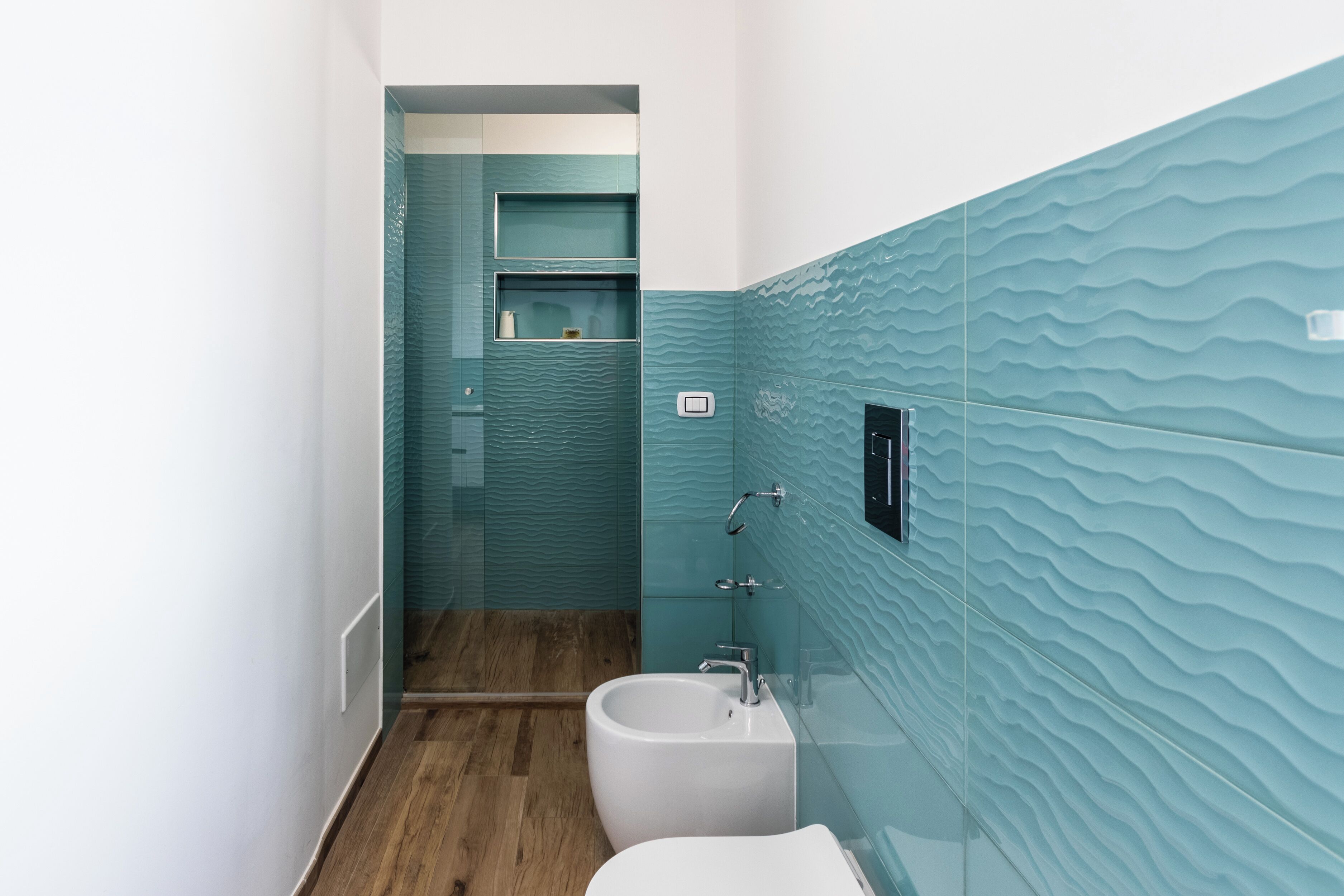 Un baño con lavamanos blanco, un bidé y una cabina de ducha de vidrio.