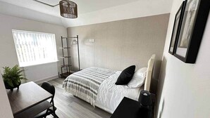 A compact bedroom with a bed, bedside table, chair, and a small desk area. - Contractor &Leisure stay.4BR all en-suite +Parking (Portsmouth)