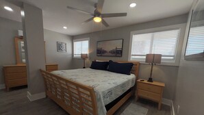 A bedroom with a wooden bed, two bedside tables, a ceiling fan, and a window with blinds. - New -1st Floor Spacious Kit W&D Close 2 Everything 3Mi To Beach Sleeps 4 KingBed (Bonita Springs)