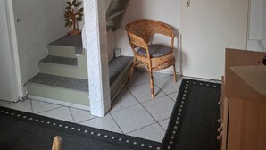 A staircase with a white wall, a wooden chair, and a door. - Holiday Home 'Blumenhof' with Shared Garden, Balcony and Wi-Fi (Wandlitz)