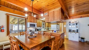 A spacious kitchen with wooden cabinets, a large island, and modern appliances. - Cub Cabin Escape: Hot Tub, Games, Fire Pit, BBQ (Big Bear)