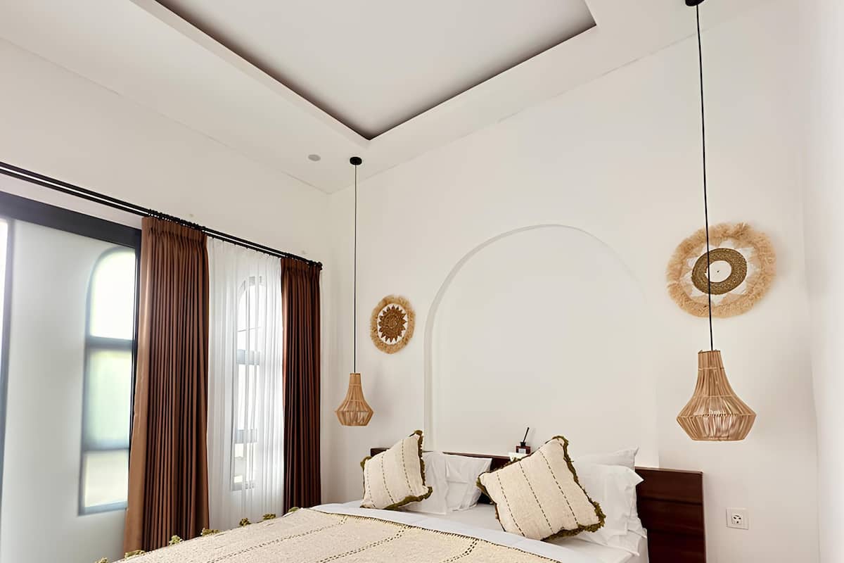 Ein modernes Schlafzimmer mit einem großen Bett, einem Oberlicht und Blick ins Freie.
