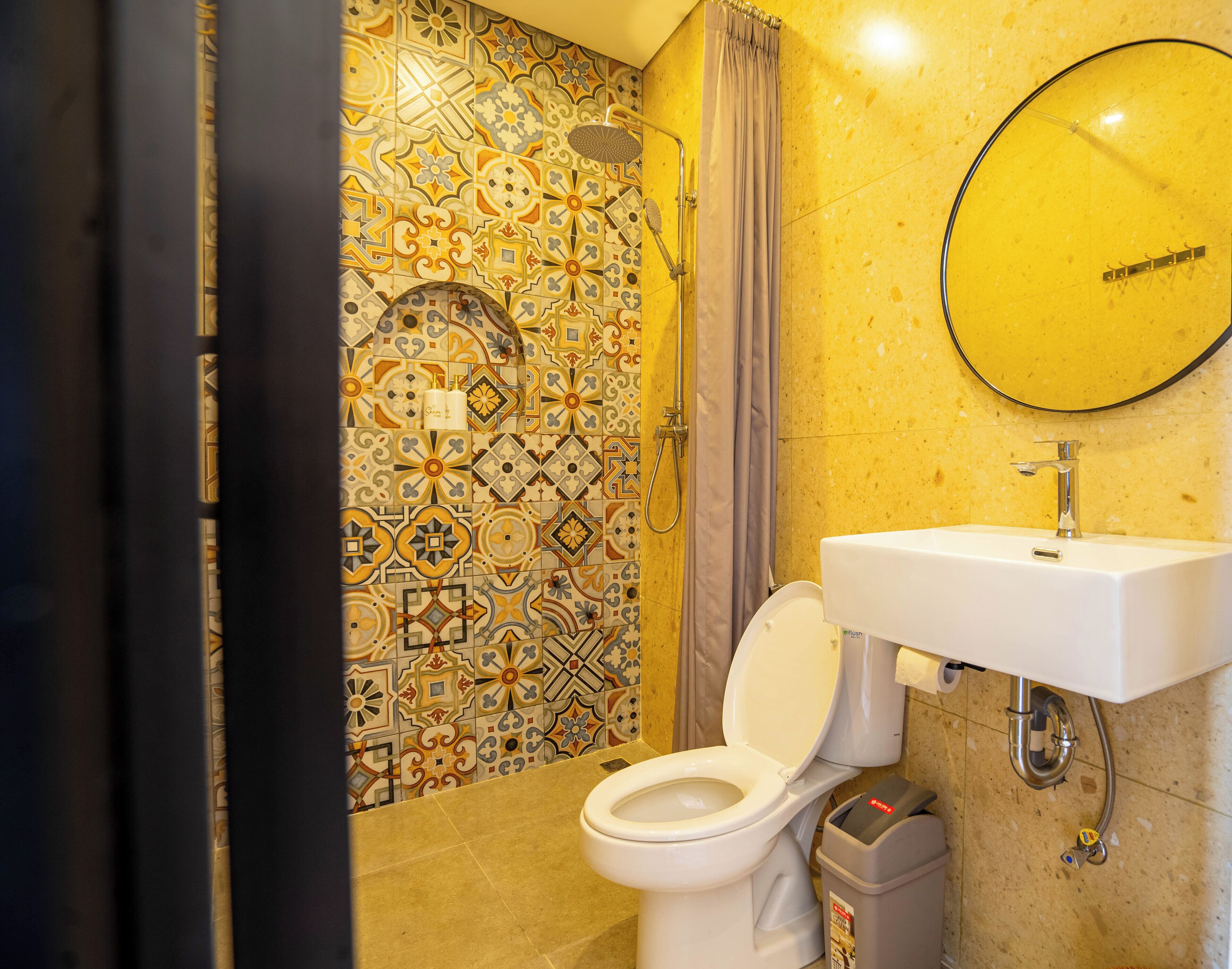 A bathroom with a white toilet, a shower, and a sink with a mirror above it.