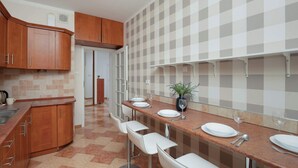 Una cucina moderna con mobili in legno, uno schienale a scacchi e un lungo bancone con sgabelli da bar.